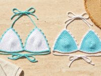 White and aqua mercerized cotton crochet bikini top colorways with picot borders laid flat on travertine stone