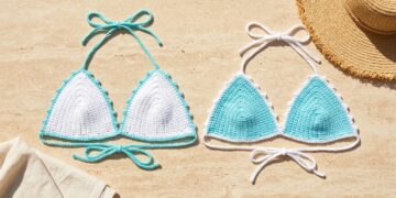 White and aqua mercerized cotton crochet bikini top colorways with picot borders laid flat on travertine stone