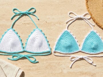 White and aqua mercerized cotton crochet bikini top colorways with picot borders laid flat on travertine stone