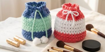 Two-color drawstring crochet makeup bag pattern in denim-mint and coral-white on a modern marble vanity