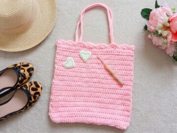 Crochet tote bag pattern in light pink yarn with scalloped shell stitch border and two straps