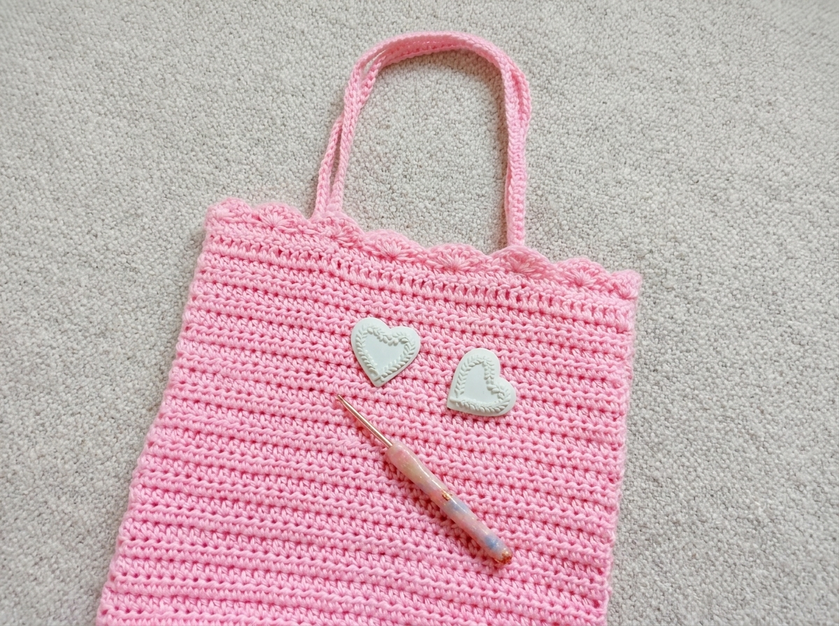 Close up of the crochet tote bag pattern showing the light pink half double crochet texture and scalloped shell stitch top border